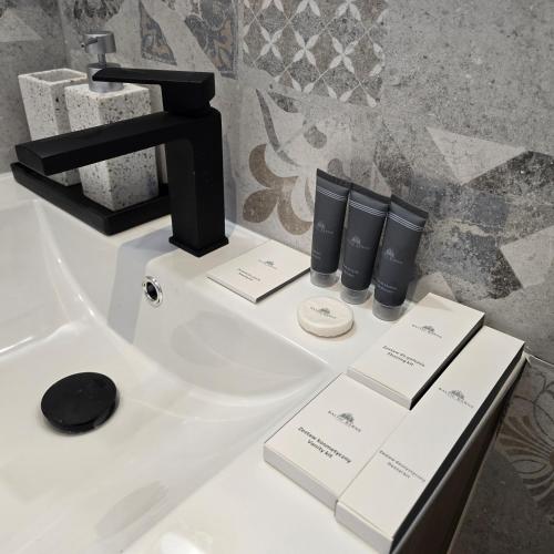 a bathroom sink with a black faucet and some cards at Baltic Barns Bura in Wytowno
