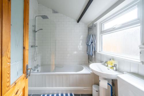 ノリッジにあるSwift Host - Golden Triangle 2 bed - Garden - Parkingの浴槽と洗面台のある白いバスルーム