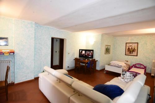 a living room with a couch and a television at Appartamento Vetta Cremolino in Cremolino