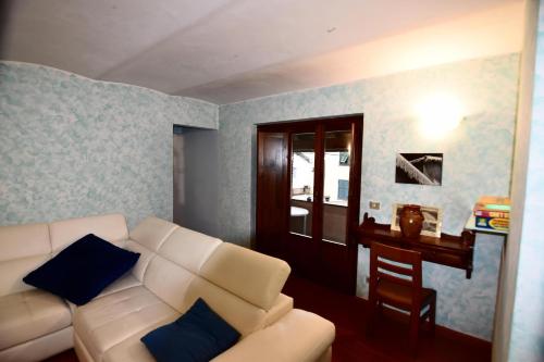 a living room with a white couch and a table at Appartamento Vetta Cremolino in Cremolino