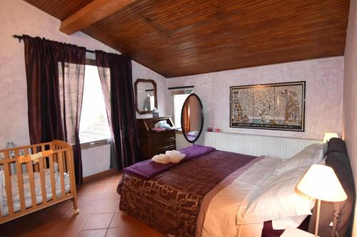 a bedroom with a bed and a crib and a mirror at Appartamento Vetta Cremolino in Cremolino