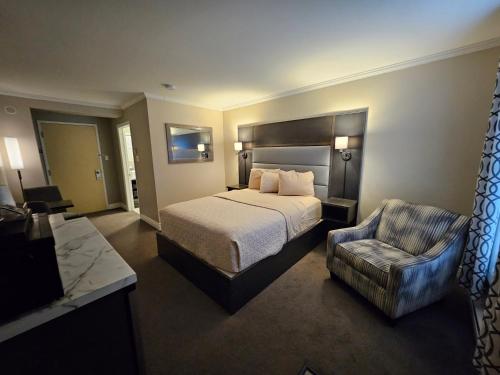 a hotel room with a bed and a chair at Newfound Inn & Suites in Topsail