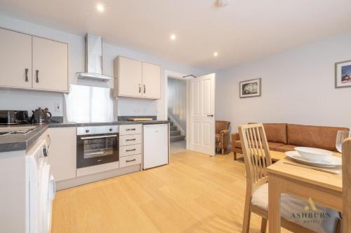 a kitchen and living room with a table and a couch at Ashburn Hotel Apartment 71A in Lurgan