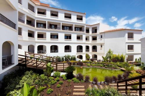 an exterior view of a building with a garden at Tivoli Lagos in Lagos