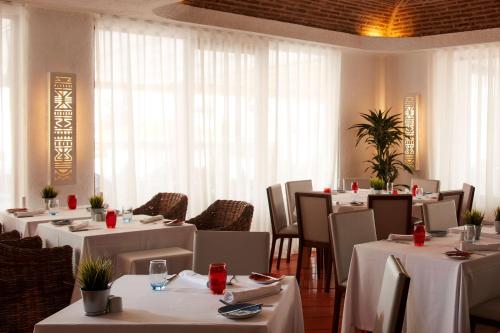 a restaurant with tables and chairs with white tablecloths at Tivoli Lagos in Lagos