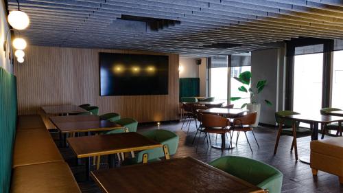 a restaurant with tables and chairs and a flat screen tv at Novotel RJ Santos Dumont in Rio de Janeiro