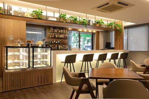 a restaurant with a bar and tables and chairs at Novotel RJ Santos Dumont in Rio de Janeiro