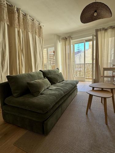 un salon avec un canapé vert et une table dans l'établissement Charming bohemian apartment, à Nice