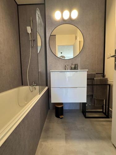 une salle de bain avec un lavabo, une baignoire et un miroir dans l'établissement Charming bohemian apartment, à Nice