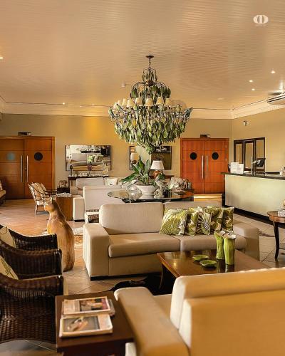 a living room with couches and a chandelier at Hotel OT in Três Lagoas