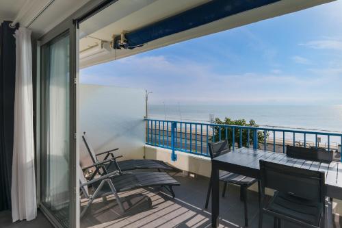 un balcon avec une table et des chaises et l'océan dans l'établissement Studio face mer, à La Baule