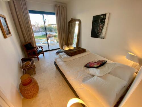 une chambre avec un lit et une grande fenêtre dans l'établissement Sur le port des Saintes, à Saintes-Maries-de-la-Mer