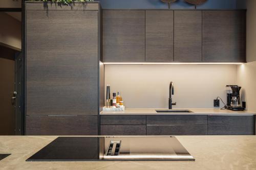 a kitchen with wooden cabinets and a sink at Penthouse with fjord view and parking in Sogndal