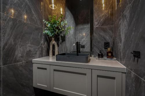 a bathroom with a sink and a black wall at Penthouse with fjord view and parking in Sogndal