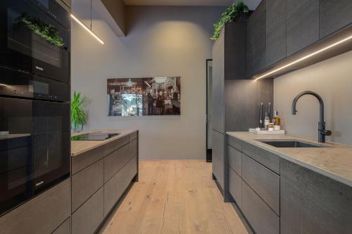 a large kitchen with two sinks and a counter at Penthouse with fjord view and parking in Sogndal