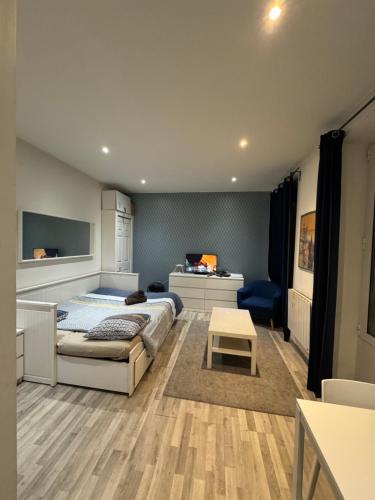 ein Schlafzimmer mit einem Bett, einem Schreibtisch und einem Tisch in der Unterkunft APPARTEMENT PROCHE CENTRE VILLE, GARE ET AUTOROUTE in Melun