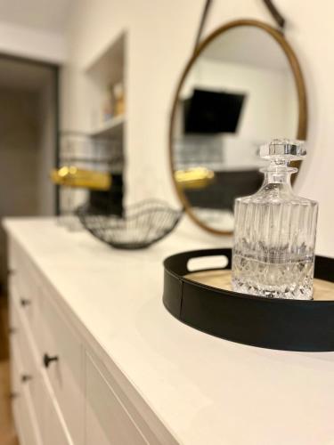 - un comptoir de salle de bains avec un miroir et une bouteille dans l'établissement Dijon city center Terrasse Alphonse, à Dijon