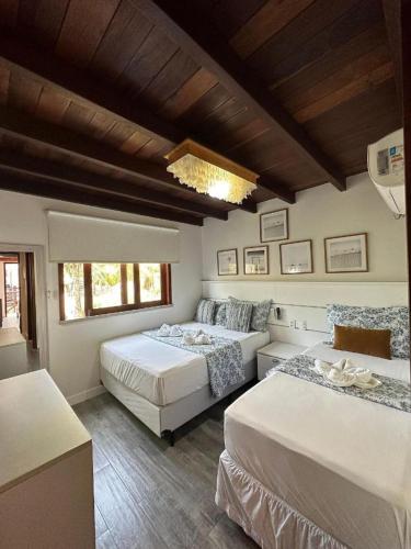 ein Schlafzimmer mit zwei Betten und einem Kronleuchter in der Unterkunft Reserva BG - Apto Praiano - Vista mar in Barra Grande