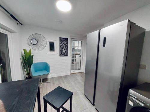 a kitchen with a black table and a blue chair at Rooms In Bury St Edmunds in Bury Saint Edmunds