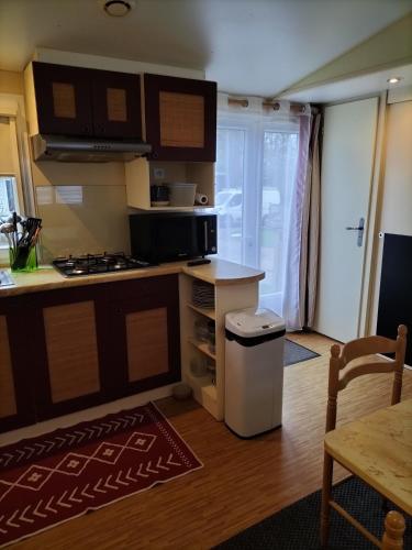 une cuisine avec une cuisinière et un comptoir dans l'établissement Mobile home, à Quimper
