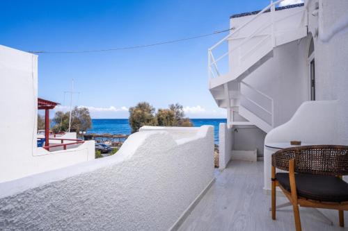 a balcony with a chair and a view of the ocean at Zen Suites & Spa in Perissa