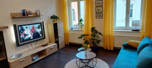 Fewo Mittags-Ruh في رايشنباخ إم فوغتلاند: غرفة معيشة مع أريكة زرقاء وتلفزيون