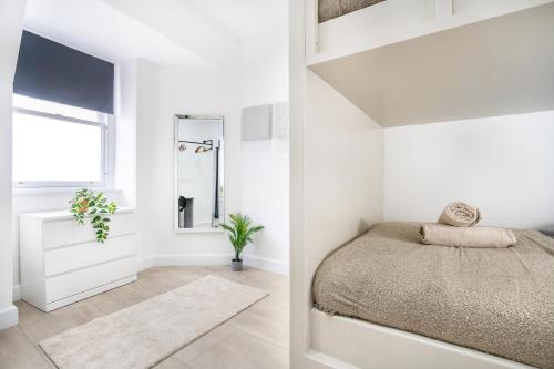 Una habitación blanca con una cama y una ventana en Luxury Apartment - Portobello, en Edimburgo