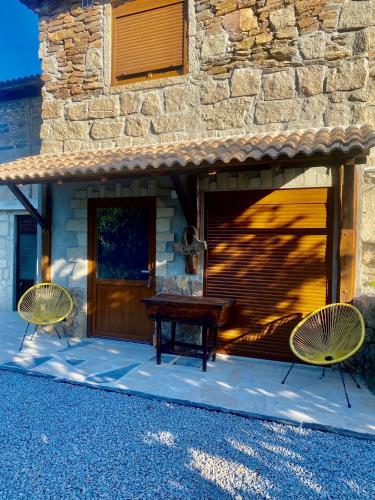 a patio with two chairs and a wooden table at O Barraco Martins T1 in Mondim de Basto