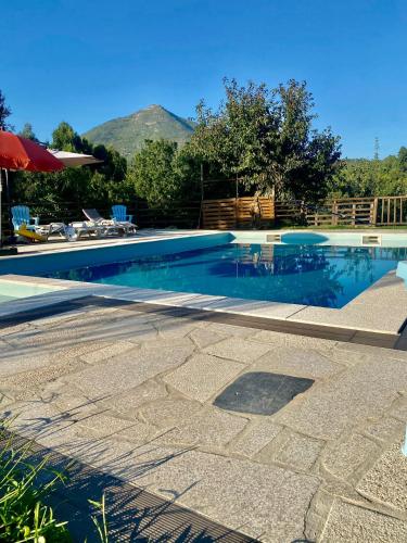 a swimming pool with blue water and mountains in the background at O Barraco Martins T1 in Mondim de Basto