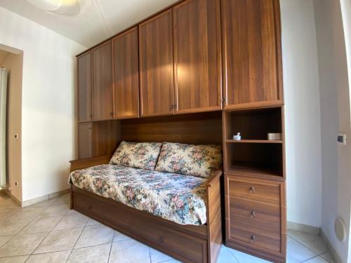 Cama en habitación con armarios de madera en Bilocale Villa Marina a pochi passi dal mare di Ceriale, en Ceriale