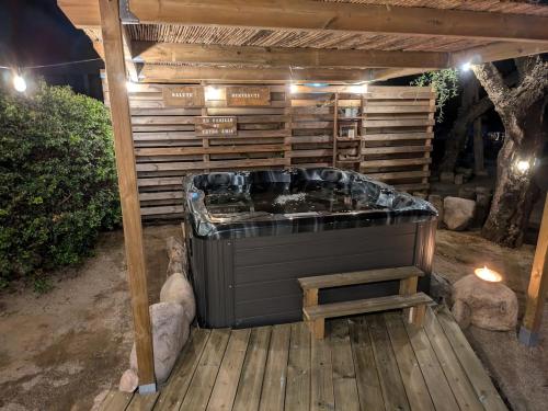 Un jacuzzi situado en una terraza de madera en L'Attellu Di Babbu pour 2, en Lecci