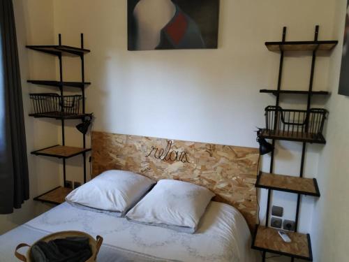 1 dormitorio con 1 cama con estanterías en la pared en L'Attellu Di Babbu pour 2, en Lecci