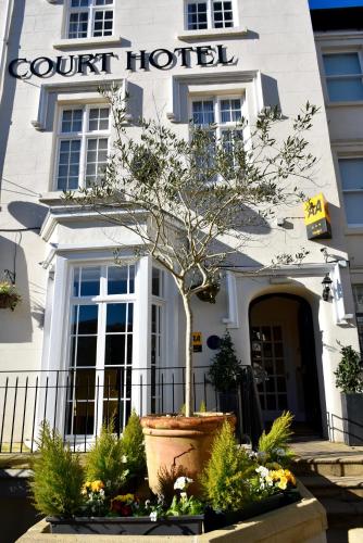 a court hotel with a tree in front of it at Queens Court Hotel in Exeter