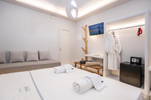 a white bedroom with a bed and a couch at Zen Suites & Spa in Perissa