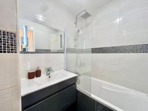 Un baño blanco con lavabo y ducha. en Le Silène T3 - 4 personnes, en Cluses