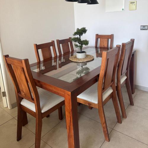 a dining room table and chairs with a potted plant at Departamento Av Los Pescadores in Coquimbo