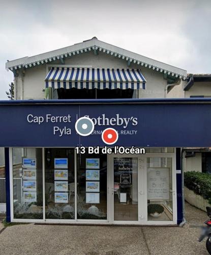 un magasin devant lequel se trouve un panneau bleu dans l'établissement Chocolatine, le loft qui donne plus de chocolat! Moulleau, Pyla-sur-Mer, à Pyla-sur-Mer