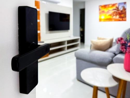a living room with a couch and a tv at Apartamento em Arraial do Cabo- Vista Mar, Piscina e Churrasqueira Privativa na Varanda a 50 m da Praia in Arraial do Cabo