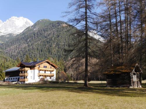 a house in a field with mountains in the background at Bucherhof in Obsteig