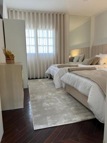 a bedroom with three beds and a large mirror at Casa São Domingos in Lousada