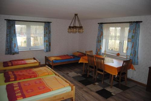 a bedroom with two beds and a table and chairs at Ländliche Ferienwohnung In Beliebtem Gästehaus in Windeby