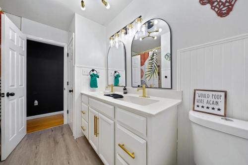 a white bathroom with a sink and a mirror at Comfort, Fun, & Charming - 5BR Oasis with Pool in Coatesville