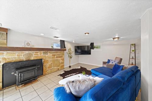 a living room with a blue couch and a fireplace at Comfort, Fun, & Charming - 5BR Oasis with Pool in Coatesville