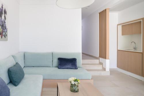 a living room with a blue couch and a table at Plus Fariones Suite Hotel in Puerto del Carmen