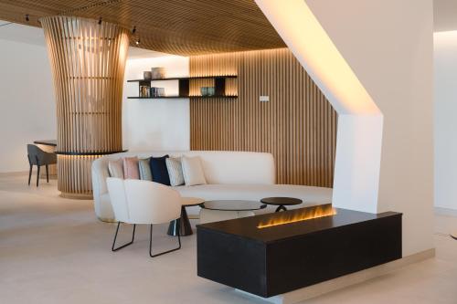 a living room with a couch and a table and chairs at Plus Fariones Suite Hotel in Puerto del Carmen