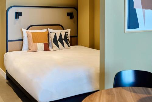 a bedroom with a bed with pillows and a table at Cityden BoLo District in Amsterdam
