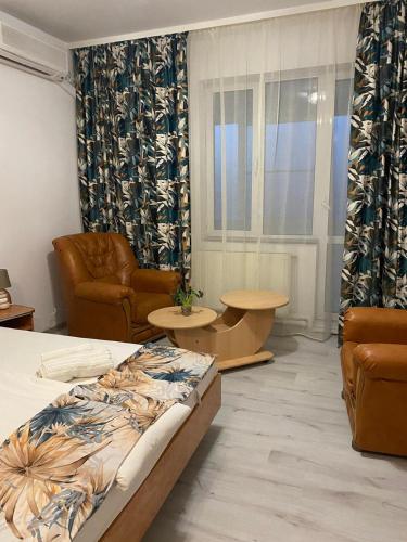 a bedroom with a bed and a couch and a table at Hotel Green House in Craiova