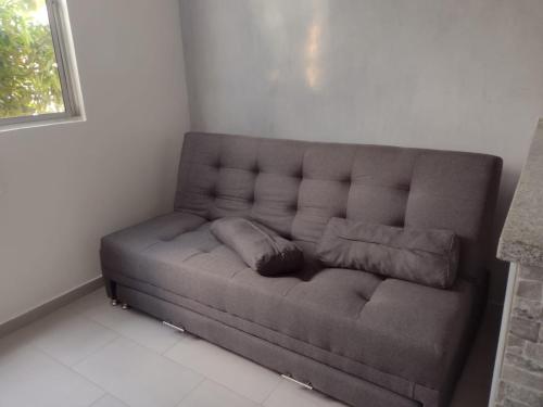 a brown couch in a room with a window at Your home away from home in Girardot in Girardot