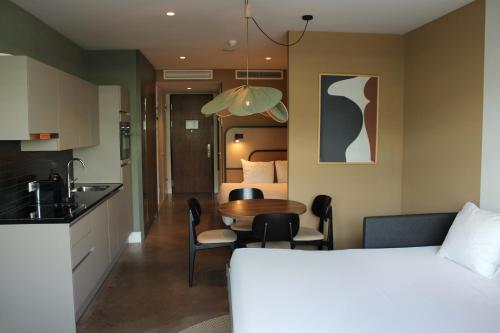 a hotel room with a bed and a table and a kitchen at Cityden BoLo District in Amsterdam