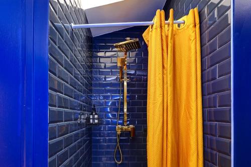 La salle de bains est pourvue d'une douche avec rideau de douche jaune. dans l'établissement Sacré Coeur, Netflix & Chill by ecoflats, à Paris